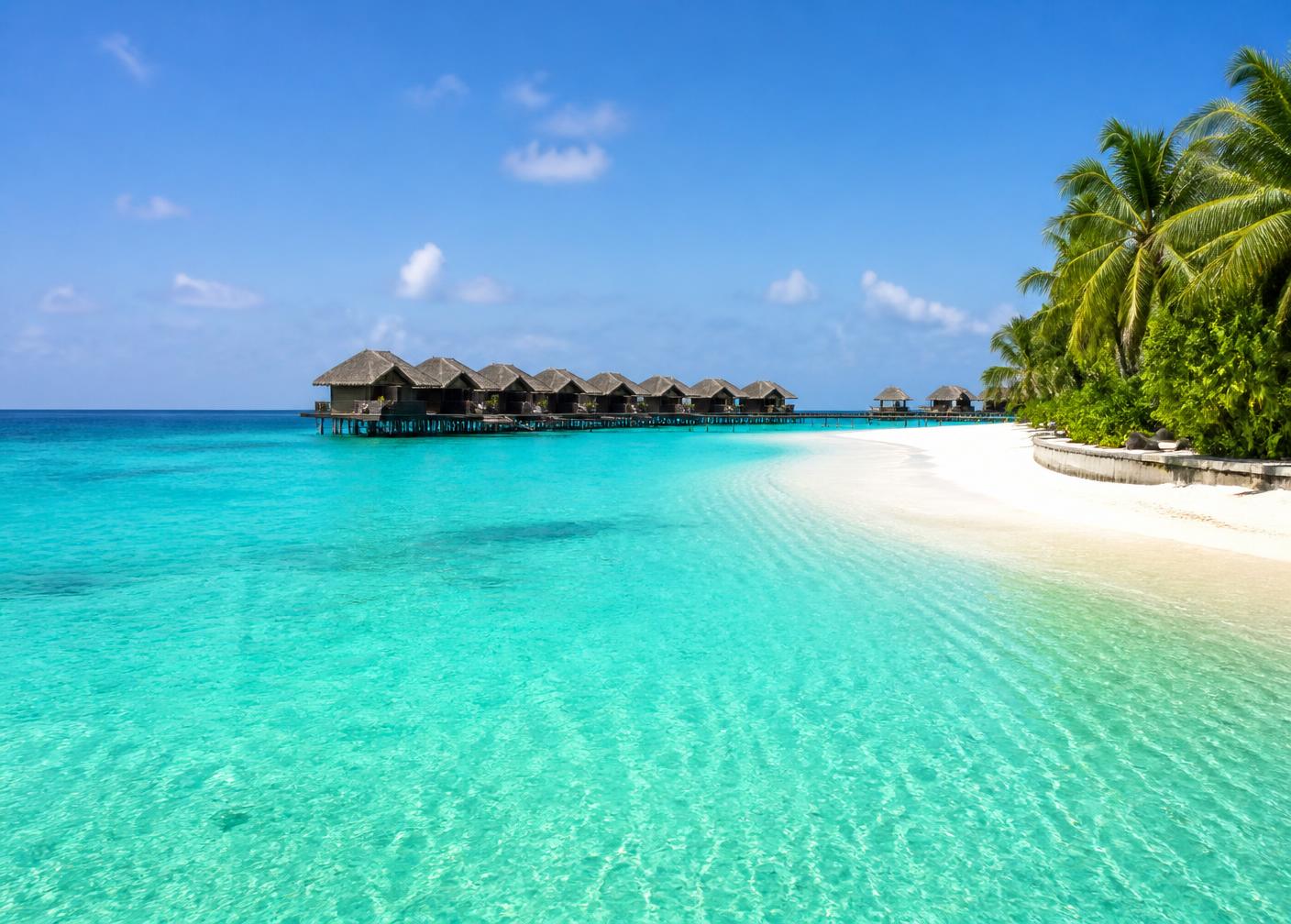Türkisfarbene Lagune mit Strand und Wasservillen auf den Malediven